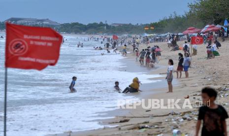 Wisatawan mengunjungi Pantai Kuta, Badung, Bali. Keputusan pembukaan Indonesia bagi wisatawan sangat tergantung dari tingkat penyebaran Covid-19.