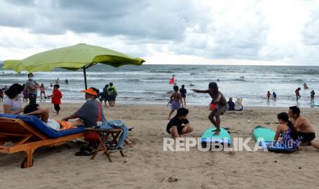 Wisatawan mengunjungi Pantai Kuta, Badung, Bali. Pemerintah akan melakukan uji coba tanpa karantina bagi Pelaku Perjalanan Luar Negeri (PPLN) yang masuk ke Bali pada 14 Maret mendatang. 