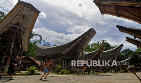 Wisatawan mengunjungi rumah adat Torajat di kawasan wisata Ketekesu, Toraja Utara, Sulawesi Selatan. Rabu (16/12/2020). Sejak ditetapkan jadi wilayah Zona Hijau di akhir Oktober lalu, sejumlah tempat wisata di Toraja Utara mulai ramai dikunjungi wisatawan dengan menerapkan protokol kesehatan. 