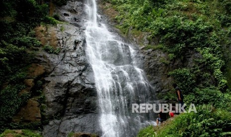 Wisatawan menikmati air terjun.