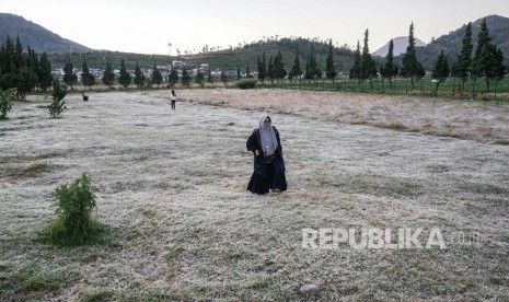 Wisatawan menikmati embun beku yang muncul akibat penurunan suhu hingga minus tujuh derajat celcius di kompleks Candi Arjuna, di dataran tinggi Dieng, Banjarnegara, Jawa Tengah, Selasa. Pemerintah Kabupaten Banjarnegara, Jawa Tengah, menginformasikan bahwa objek wisata Dieng siap dibuka dengan protokol kesehatan yang sangat ketat.