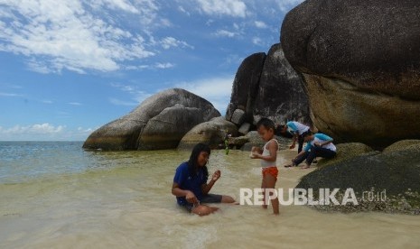 Wisatawan menikmati keindahan di Pantai Tanjung Tinggi, Belitung, Kamis (10/3). Pemerintah Kabupaten Belitung, Provinsi Kepulauan Bangka Belitung mendorong tercapainya kekebalan komunal melalui vaksinasi COVID-19.