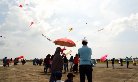 Wisatawan menikmati layang-layang yang diterbangkan di ajang Festival Layang-Layang Internasional 2018 di Ranai, Kabupaten Natuna, Kepulauan Riau