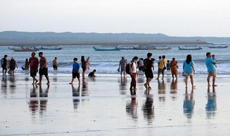 Wisatawan menikmati liburan di Pantai Kuta, Badung, Bali.