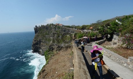  Wisatawan menikmati pemandangan pantai Uluwatu yang terletak di Uluwatu, Bali, Jumat (20/11). 