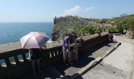  Wisatawan menikmati pemandangan pantai Uluwatu yang terletak di Uluwatu, Bali, Jumat (20/11). 