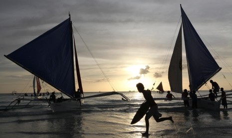 Wisatawan menikmati senja di Pantai Boracay, Filipina.