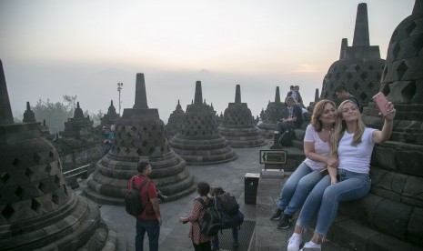 Wisatawan menikmati suasana matahari terbit di kawasan Taman Wisata Candi (TWC) Borobudur, Magelang, Jawa Tengah, Sabtu (18/5/2019).