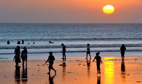 Wisatawan menikmati suasana senja di Pantai Kuta, Badung, Bali, Jumat (14/5/2021). Salah satu destinasi wisata utama di Pulau Dewata tersebut dipadati oleh ribuan wisatawan lokal selama masa liburan Hari Raya Idul Fitri 1442 Hijriah.