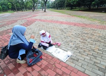 Wisatawan menunaikan salat wajib di trotoar kawasan Monumen Nasional, Jakarta Pusat, Senin (2/1). (Republika/Aditya Pradana Putra)