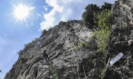 Wisatawan menuruni tebing dengan menggunakan teknik rapling di Tebing Citatah 125, Padalarang, Bandung, Jawa Barat, 