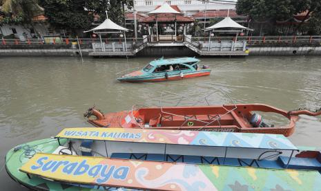 Wisatawan menyusuri sungai dengan perahu wisata di Sungai Kalimas, Surabaya, Jawa Timur, Jumat (15/4/2022). Wisata Perahu Kalimas yang berada di pusat Kota Surabaya tersebut merupakan salah satu pilihan wisata bagi warga Surabaya dan sekitarnya untuk memanfaatkan libur Paskah.