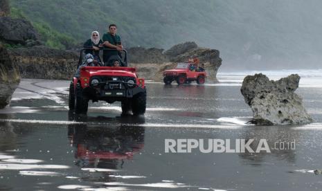 Wisatawan naik mobil jip wisata menyusuri Pantai Parangtritis, Kretek, Bantul, DI Yogyakarta. Pebisnis wisata diharapkan sudah bisa menyusun strategi jelang masa liburan akhir tahun karena pemerintah sudah menerbitkan aturan PPKM Level 3 sejak jauh hari.