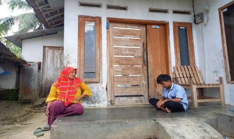 Wiwin (30 tahun), bersama anaknya, Irsyad (13), di rumahnya, Kampung Hergamanah, Desa Ciawang, Kecamatan Leuwisari, Kabupaten Tasikmalaya, Senin (9/1/2023). Irsyad merupakan salah satu korban keracunan ciki ngebul di Kabupaten Tasikmalaya beberapa waktu lalu.