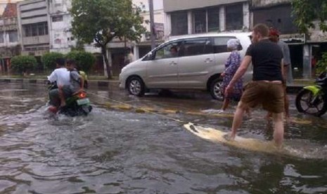 WN Selandia Baru, Daniel asyik bermain selancar di tengah-tengah banjir Glodok, Jakarta Barat, Jumat (18/1).