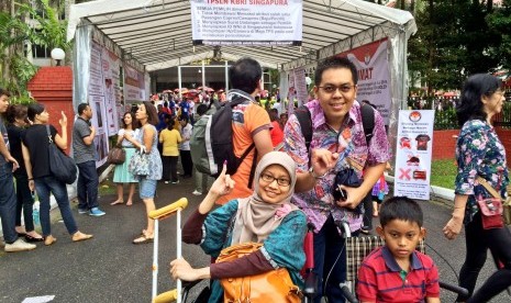 WNI menunjukkan jarinya yang bertinta biru sebagai pertanda mereka telah menggunakan hak pilihnya dalam Pemilu 2019 di KBRI Singapura.