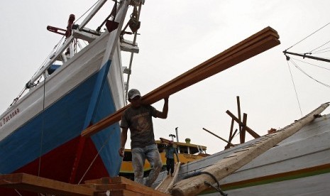 Worker unload timber from a ship in Sunda Kelapa Port in Jakarta (illustration)