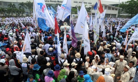 Workers hold a rally in Cibitung, West Java, on Wednesday, as they demand the wage increase and the revocation of oursourcing system.  