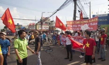 Workers wave Vietnamese national flags during a protest at an industrial zone in Binh Duong province May 14, 2014.