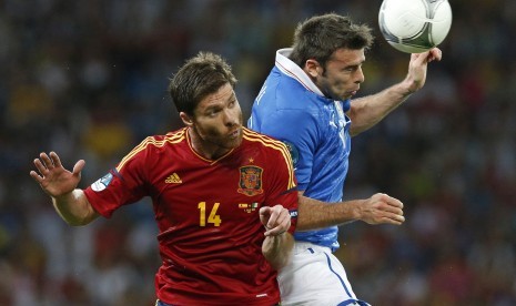 Xabi Alonso berduel udara dengan Andrea Barzagli  