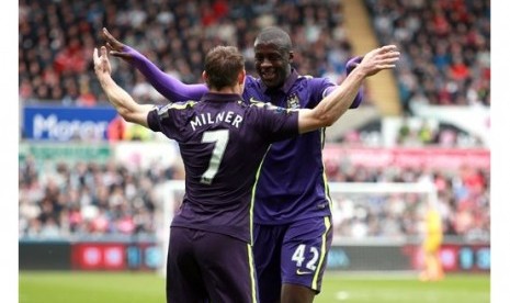 Yaya Toure (kanan) berpelukan dengan James MIlner