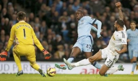 Yaya Toure saat mencetak gol ke gawang Swansea City, Sabtu (22/11).