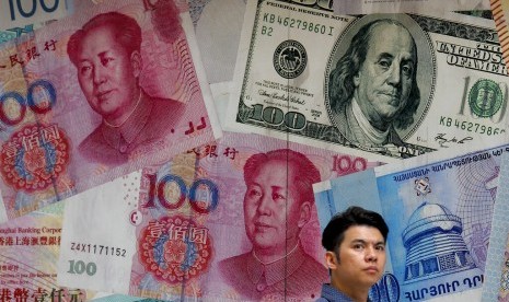 YUAN. Seorang warga melintasi kantor penukaran uang asing yang dihiasi gambar uang berbagai negara di Hong Kong, Selasa (6/8). Nilai tukar yuan Cina merosot tajam atas dolar AS sebagai akibat dari perang dagang dengan Amerika Serikat.