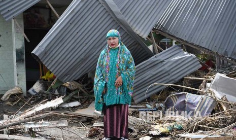 Yuslifa berpose di depan rumahnya yang rusak akibat likuifkasi di Lere, Palu, Sulawesi Tengah.