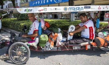 Yusuf (kanan) dan Jabbari (kiri) di atas motor tenaga surya mereka.