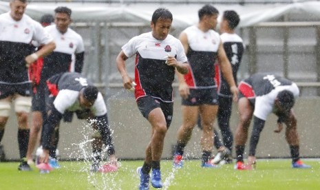 Yutaka Nagare (tengah) dari tim rugbi Jepang berlatih untuk Piala Dunia Rugbi pool A di saat Topan Hagibis menerjang, Sabtu (12/10).