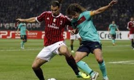 Zlatan Ibrahimovic berebut bola dengan Carles Puyol