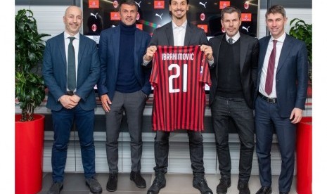 Zlatan Ibrahimovic (tengah) memegang kostum bernomor 21 yang akan dia kenakan selama memperkuat AC Milan.