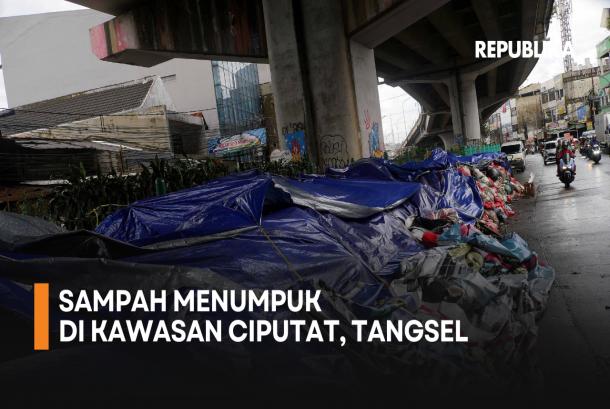 Pengendara motor melintas di samping tumpukan sampah yang ditutupi terpal di Ciputat, Tangerang Selatan, Banten, Selasa (16/12/2025).
