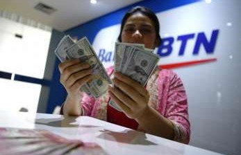 Petugas menghitung uang dolar Amerika Serikat di gerai penukaran mata uang Bank BTN, Jakarta (ilustrasi).