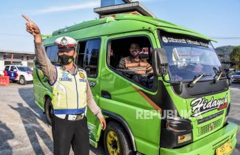 Petugas kepolisian memutarbalikan kendaraan angkutan umum di posko penyekatan larangan mudik di Jalan Nanggeleng, Limbangan, Kabupaten Garut, Ahad (9/5). Memasuki hari keempat penerapan larangan mudik Lebaran 2021, petugas gabungan di posko penyekatan larangan mudik Limbangan telah memutarbalikan sedikitnya 150 kendaraan berplat luar kota dari arah Bandung menuju Garut dan Tasikmalaya karena tidak memiliki surat kesehatan serta ijin perjalanan. 