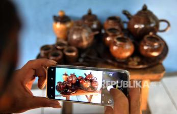 Pekerja memotret kerajinan dari bahan limbah batok kelapa yang dipasarkan secara daring di Saung Oprek Karajinan Batok (Karabat), Kelurahan Menteng, Kota Bogor, Jawa Barat, Senin (29/6/2020). Gojek akan mendukung Kementerian Komunikasi dan Informatika (Kominfo) dalam mempercepat digitalisasi UMKM. ANTARA FOTO/Arif Firmansyah/pras.