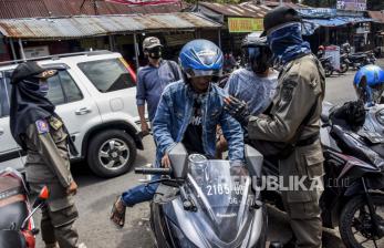 Petugas Satpol PP Kota Cimahi menegur warga yang tidak menggunakan masker di kawasan Taman Alun-alun Kota Cimahi, Jalan Raya Barat, Kota Cimahi, Rabu (12/8). Pemerintah Kota Cimahi menerapkan sanksi denda sebesar Rp150 ribu serta sanksi sosial yakni kewajiban membersihkan area publik bagi warga yang tidak menggunakan masker di tempat umum. Foto: Abdan Syakura/Republika