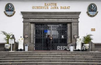 Petugas keamanan mengunci pintu utama Gedung Sate saat penutupan sementara di Jalan Diponegoro, Kota Bandung, Kamis (3/6). Sebanyak 32 Aparatur Sipil Negara (ASN) di Gedung Sate atau Kantor Gubernur Jawa Barat terkonfirmasi positif Covid-19 sehingga selama tujuh hari Gedung Sate ditutup untuk publik dan aktivitas ASN serta non pegawai untuk sementara bekerja dari rumah. Foto: Republika/Abdan Syakura