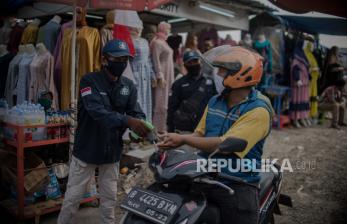 Petugas menyemprotkan cairan pembersih tangan kepada  pengunjung di Pasar Tasik, Jakarta, Kamis (11/6). Aktivitas ekonomi di pasar tersebut kembali dibuka meski jumlah pengunjung belum ramai namun penerapan protokol kesehatan dan pembatasan jumlah pengunjung sudah diberlakukan pada masa transisi pembatasan sosial berskala besar (PSBB) di Jakarta