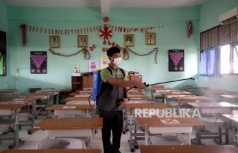 Petugas menyemprotkan disinfektan di SMPN 252, Jakarta saat penghentian sementara kegiatan PTM (Pembelajaran Tatap Muka) setelah terdapat satu siswa yang positif Covid-19, Jumat (14/1/2022). Pemprov DKI Jakarta tetap akan menggelar Pembelajaran Tatap Muka (PTM) 100 persen, walau saat ini sudah ada beberapa sekolah yang ditutup sementara akibat ditemukannya kasus Covid-19 saat PTM berlangsung.