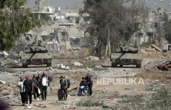 Warga Palestina mengungsi ke Gaza utara ketika tank-tank Israel memblokir jalan Salah al-Din di Jalur Gaza tengah pada hari Jumat, (24/11/2023).