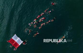 In Picture: Semarak HUT RI, Perenang Arak Bendera Merah Putih di Perairan Makassar