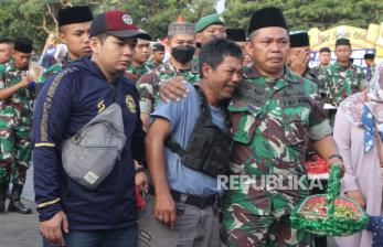 Anggota TNI AD dari Yon Zipur 5 merangkul seorang suporter Arema FC (Aremania) usai doa bersama di depan Tugu Singa, Stadion Kanjuruhan, Malang, Jawa Timur, Selasa (4/10/2022). Kegiatan tersebut untuk mendoakan para korban tragedi Kanjuruhan yang menelan ratusan korban. 