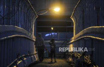 Seorang anak bersama ibunya berjalan melewati JPO di kawasan Pancoran, Jakarta, Rabu (11/5/2022).Satgas Penanganan Covid-19 menyatakan Indonesia sudah mulai melakukan transisi dari pandemi menuju fase endemi dengan pertimbangan angka kasus Covid-19 berada dibawah 1.000 selama 25 hari terakhir, keterisian tempat tidur rumah sakit berada di angka 2 persen dan menurunnya angka kematian. Republika/Putra M. Akbar