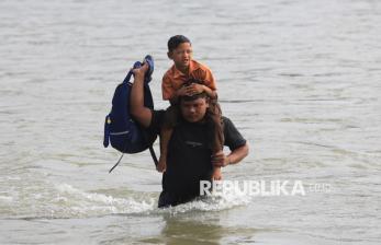 Orang Tua Gendong Anak Seberangi Sungai Demi Mengikuti Ujian Kenaikan Kelas