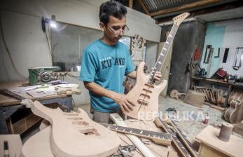 Perajin menyelesaikan pembuatan gitar  di sentra produksi gitar rumahan Arya Guitar Custom di kawasan Klapanunggal, Kabupaten Bogor, Jawa Barat, Sabtu (28/3/2020). Kementerian Koperasi dan UKM menyiapkan dua stimulus khusus yaitu diskon 25 persen untuk konsumen sebanyak 2 juta orang dan bantuan tunai untuk sektor mikro, hal itu untuk peningkatan daya beli terhadap produk UMKM di tengah pandemi virus corona atau Covid-19