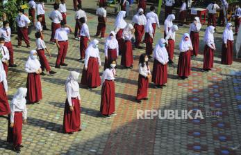 Sejumlah siswa berjemur dalam pengawasan guru di halaman sekolah sambil mengenakan masker saat hari pertama dimulainya kembali pembelajaran tatap muka di SDN 47/IV, Kota Jambi, Jambi, Senin (1/3). Pemerintah Kota Jambi menerapkan kembali pembelajaran tatap muka dengan protokol kesehatan dan sistem bergantian di tingkatan sekolah SD dan SMP mulai 1 Maret 2021.
