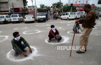 Pemimpin Muslim di India Bela Jamaah Tabligh. Petugas polisi Jammu dan Kashmir memaksa orang untuk berjongkok di dalam lingkaran yang ditandai untuk menjaga jarak sosial minimum di Jammu, India, Rabu (25/3). Perdana Menteri India Narendra Modi mengumumkan penguncian 21 hari di seluruh India, yang dimulai pada 24 Maret, dalam upaya untuk memperlambat penyebaran pandemi penyakit COVID-19 yang disebabkan oleh coronavirus SARS-CoV-2