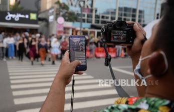 Warga mengambil gambar saat peragaan busana di zebra cross di kawasan Dukuh Atas, Jakarta, Kamis (28/7/2022). Wakil Gubernur DKI Jakarta Ahmad Riza Patria mengimbau warga yang melakukan peragaan busana di zebra cross untuk pindah ke trotoar agar tidak mengganggu arus lalu lintas. 