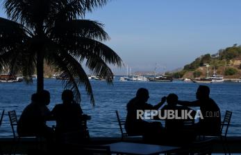 Siluet wisatawan mancanegara menikmati santapan dengan pemandangan perairan Labuan Bajo di Kabupaten Manggarai Barat, NTT. Pelaku wisata di Labuan Bajo mengeluhkan penurunan jumlah wisatawan ke Komodo.